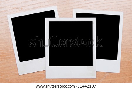  instant photo frames on wooden background