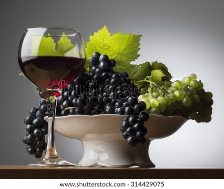 Glass of red wine with grapes