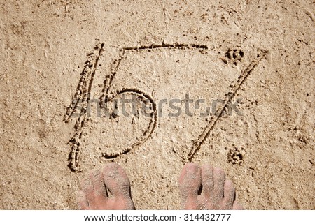 Conceptual 5% handwritten in sand for natural, symbol, tourism or conceptual designs with feet
