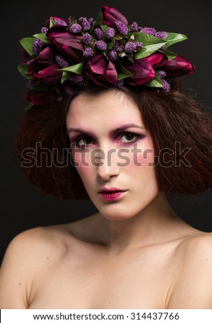 Studio photos girls with beautiful flowers on the head and a stylish makeover on a black background
