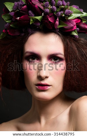Studio photos girls with beautiful flowers on the head and a stylish makeover on a black background
