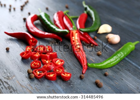 Hot peppers with spices on wooden table close up Royalty-Free Stock Photo #314485496