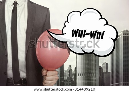 Win win text on speech bubble with businessman holding balloon on cityscape background