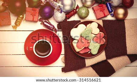 Cup of coffee and cookies near christmas toys.