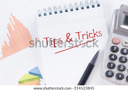 Tips and Tricks concept - Financial accounting stock market graphs analysis. Calculator, notebook with blank sheet of paper, pen on chart. Top view