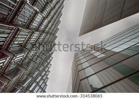 An abstract HDR coloured photo looking up capturing three different buildings on a horizontal degree angle with an applied HDR filter. Image has an added light green tint colour and extra contrast 