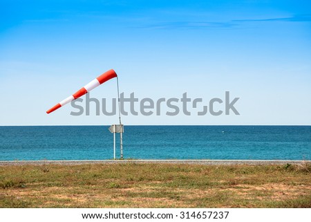 Big wind sock direction on blue sea shore