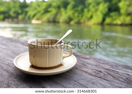  Empty coffee cup on old wooden floor riverside on background