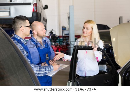Two mechanics trying to cheat female client at workshop