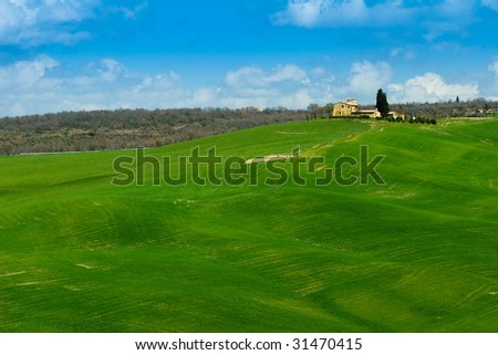 Green spring fields with farm in tuscany