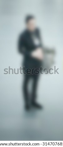 Man standing alone, generic background, intentionally blurred post production.