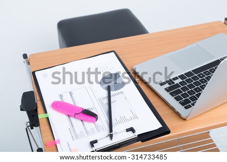 workplace with laptop and papers