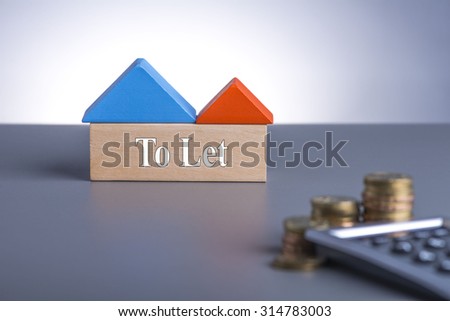 Housing Loan concept. House Wooden Block, coins and calculator with word To Let
