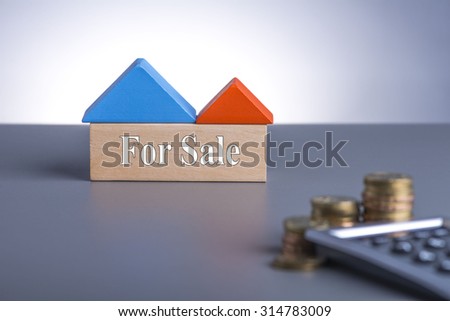 Housing Loan concept. House Wooden Block, coins and calculator with word For Sale
