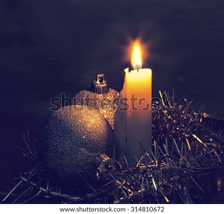 Big burning candle and New Year's Christmas tree decorations