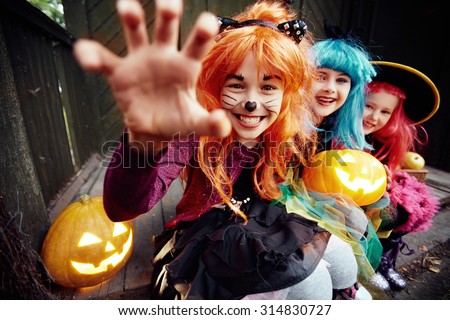 Halloween girl looking at camera with her hand in frightening gesture
