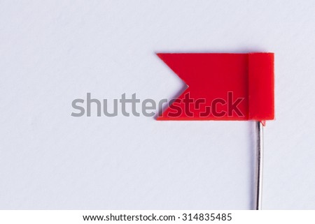 Red Flag Push Pin on white background for concepts of important tasks, danger and risk