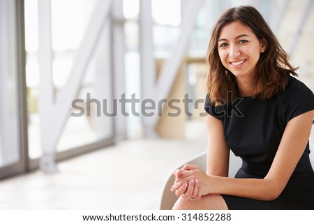 Portrait of young mixed race Asian businesswoman sitting Royalty-Free Stock Photo #314852288