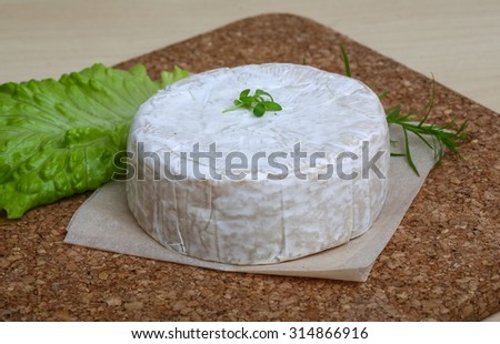 Camembert brie cheese with herbs on the wood background