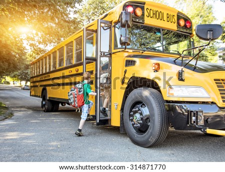 A group of young children getting on the schoolbus Royalty-Free Stock Photo #314871770