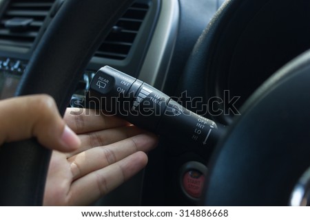 man hand use the signal switch. Car interior detail with blue light. Royalty-Free Stock Photo #314886668