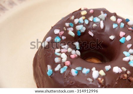 A donut with chocolate icing and decoration.
