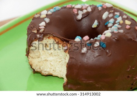 Chocolate donut served on the green plate.