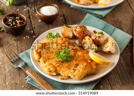 Homemade Breaded German Weiner Schnitzel with Potatoes Royalty-Free Stock Photo #314919089