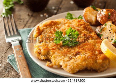 Homemade Breaded German Weiner Schnitzel with Potatoes Royalty-Free Stock Photo #314919200