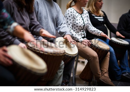 Group of people playing on drums - therapy by music