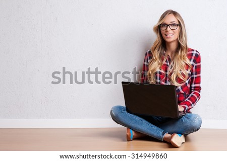 Young creative woman sitting in the floor with laptop./ Casual blogger woman Royalty-Free Stock Photo #314949860