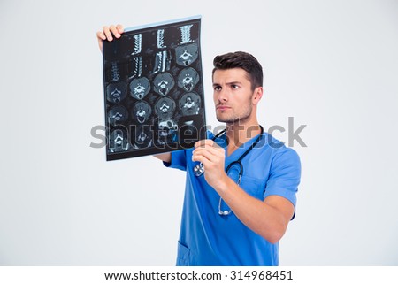 Portrait of a handsome male doctor looking at x-ray picture of brain isolated on a white background
