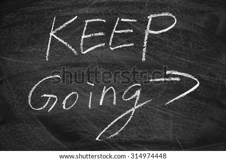 Keep Going on the blackboard with chalk writing.