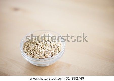 Bowl of buckwheat groats on wooden table