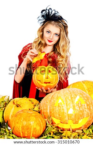 Pretty teen girl with blonde hair in a costume of witch posing with pumpkins. Halloween. Isolated over white background. 