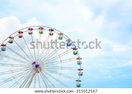 Ferris wheel on cloudy sky background Royalty-Free Stock Photo #315012167