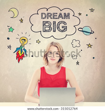 Dream Big concept with young woman working on a laptop 