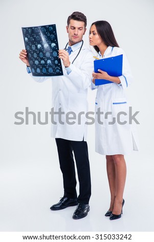 Full length portrait of a two medical workers looking at x-ray picture of brain isolated on a white background
