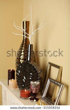 Modern vases with decor on fireplace in room