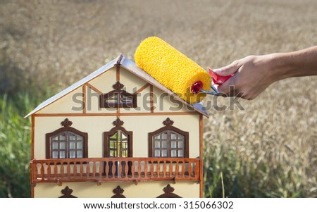 Concept of home renovation. House in a field sunny day.