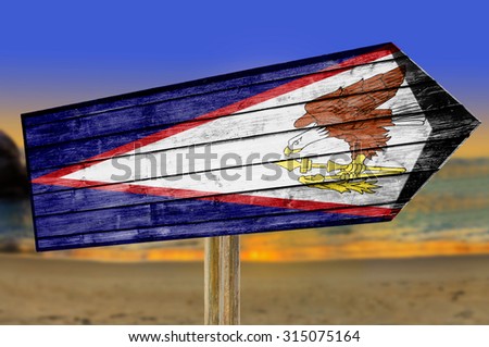American Samoa Flag wooden sign on beach background