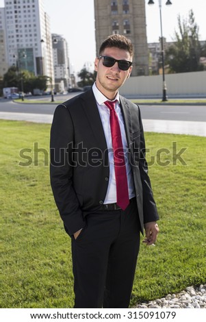  Young businessman  in a suit and glasses and red tie.