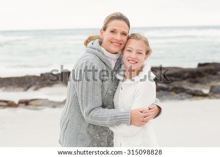 Mother and daughter hugging at the beach