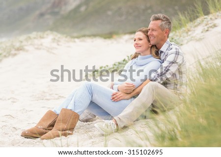 Smiling couple sitting together at the beach