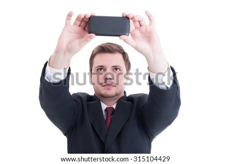 Young business person taking a selfie using phone camera or smartphone isolated on white
