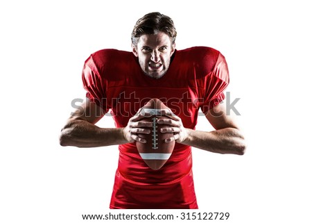 Portrait of angry American football player in red jersey holding ball on white background