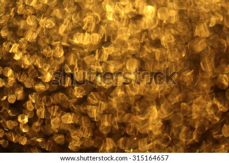 Closeup of beautiful glowing bright abstract golden metal shiny empty bokeh copyspace background with sparkles, horizontal picture
