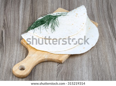 Mexican Tortillas with dill leaves on the wood background
