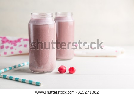 Two bottles of cherry smoothie isolated on white background
