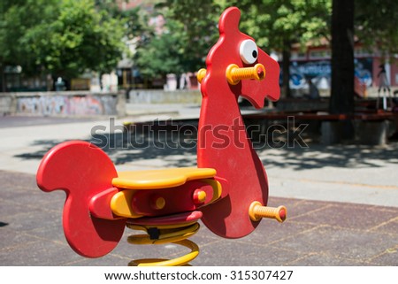 Plastic horse toy in a park. Children love to play with it, because it goes back and forth when you swing